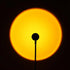 Sunset projection lamp illuminating room with colorful light