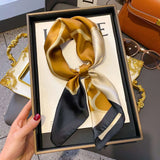 Elegant silk-feel scarf featuring intricate patterns, used as a headband or hair accessory
