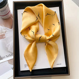 Elegant silk-feel scarf featuring intricate patterns, used as a headband or hair accessory