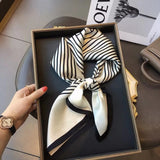 Elegant silk-feel scarf featuring intricate patterns, used as a headband or hair accessory
