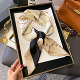 Elegant silk-feel scarf featuring intricate patterns, used as a headband or hair accessory