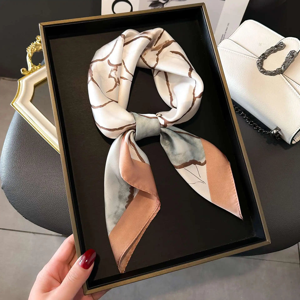 Elegant silk-feel scarf featuring intricate patterns, used as a headband or hair accessory