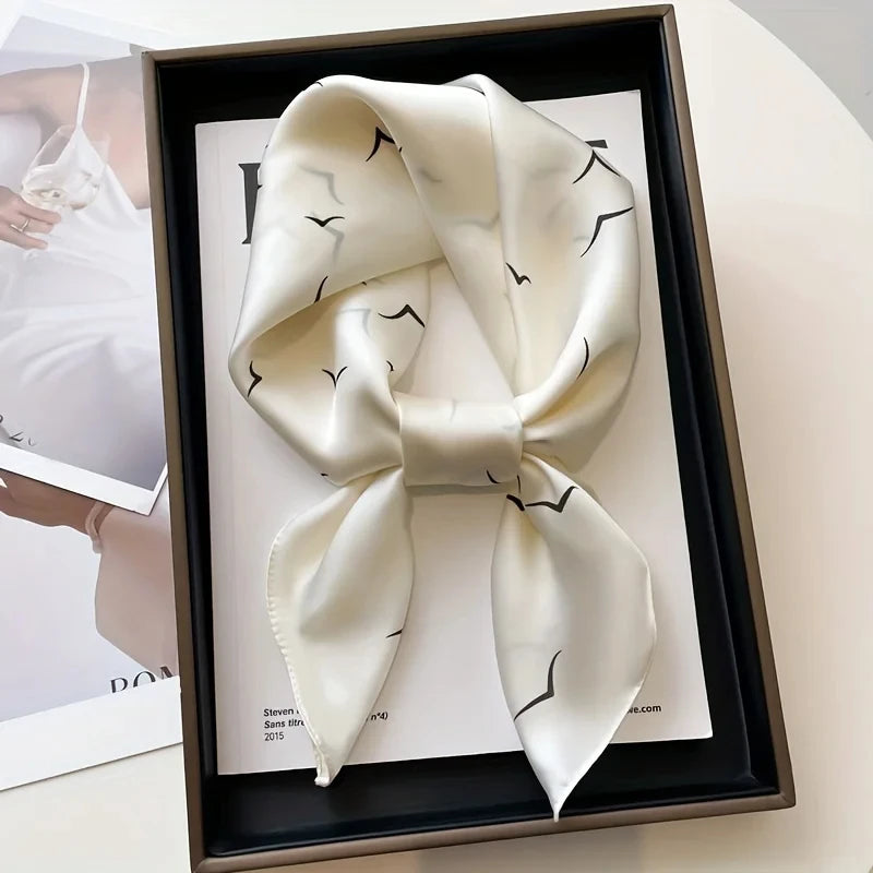 Elegant silk-feel scarf featuring intricate patterns, used as a headband or hair accessory